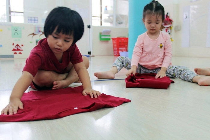 Cha mẹ trải ga nệm phẳng và căng cho bé