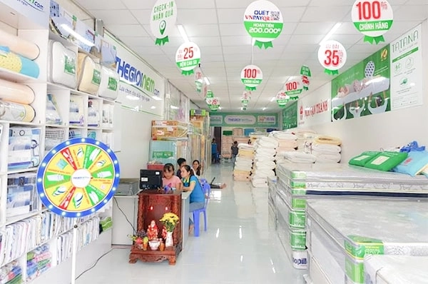 khách hàng thử độ cứng nệm Liên Á trong cửa hàng